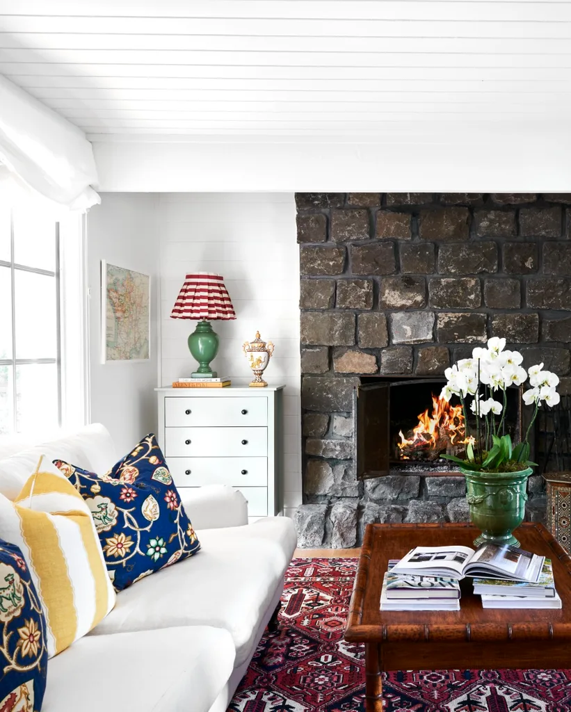 Light living room with white sofa and stone fireplace