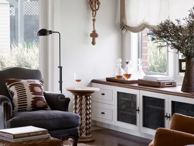 Cottage living room with Austrian blinds and build in cabinetry