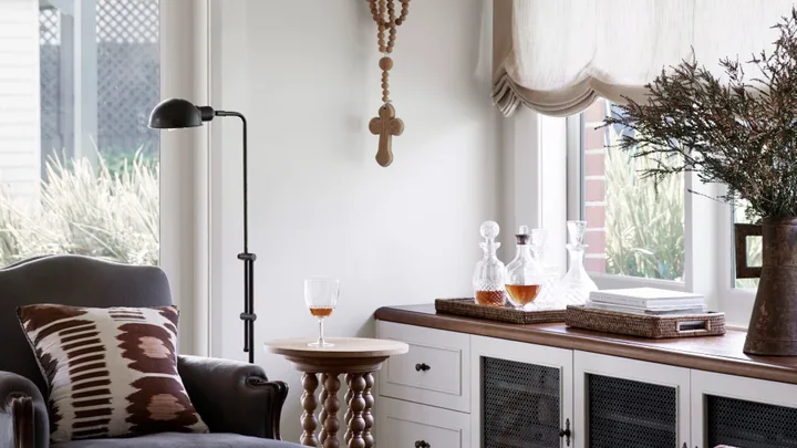 Cottage living room with Austrian blinds and build in cabinetry