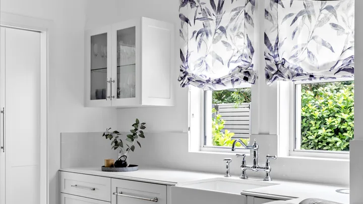 White kitchen with relaxed Roman blinds in blue and white printed linen
