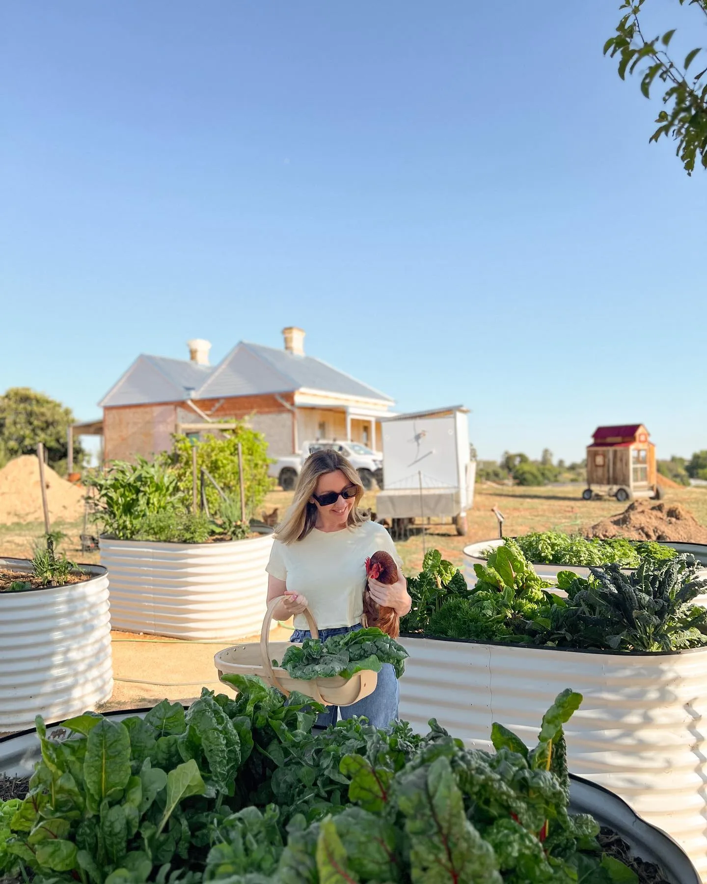 Jenna Densten in the vegetable garden of her Rutherglen home, holding a chicken.
