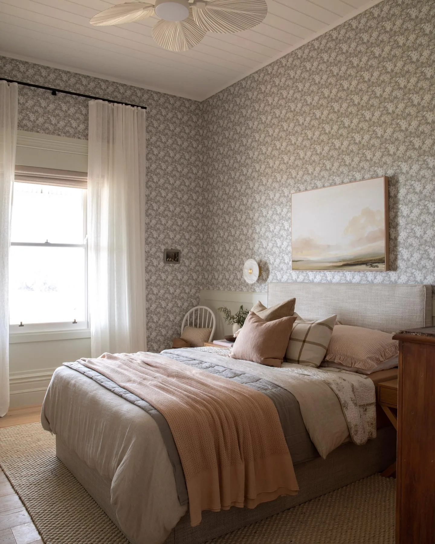 Guest bedroom with floral wallpaper in a restored country homestead.