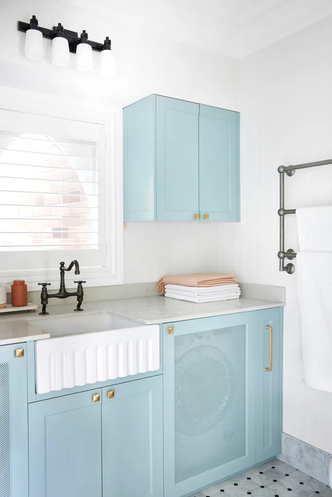 Blue and white laundry with concealed appliances and gold, nickel and brass hardware.