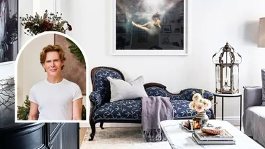 A living room with an antique blue chaise longue, and an image of Loui Burke inset