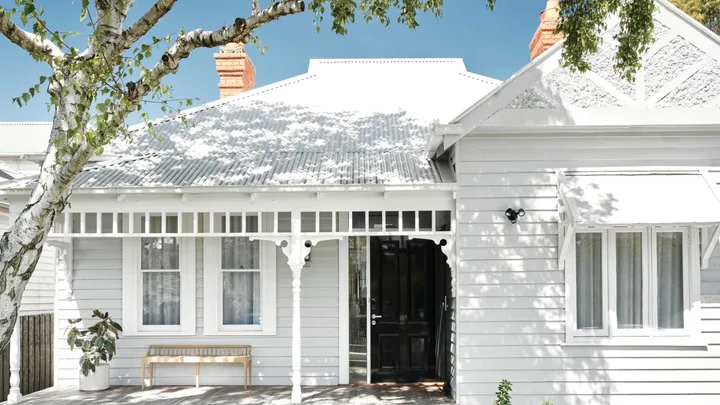 Renovated white Victorian cottage facade.
