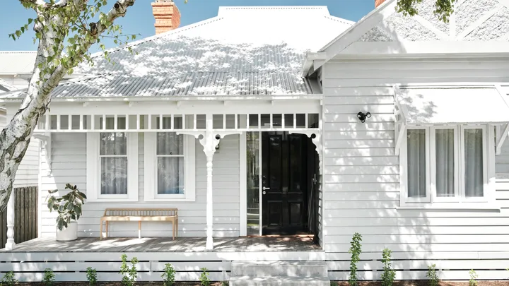 Renovated white Victorian cottage facade.