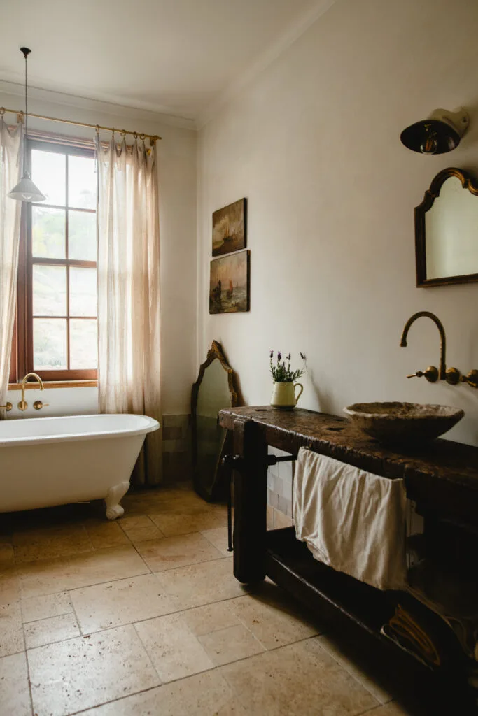 Modern country bathroom with wooden basin and clawfoot bathtub.