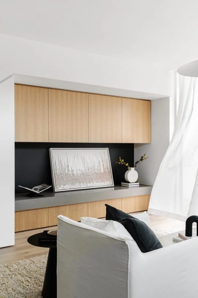 Living room hidden wooden storage cabinet and white curtains.