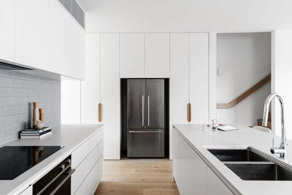 Contemporary white kitchen and finger tile splashback.