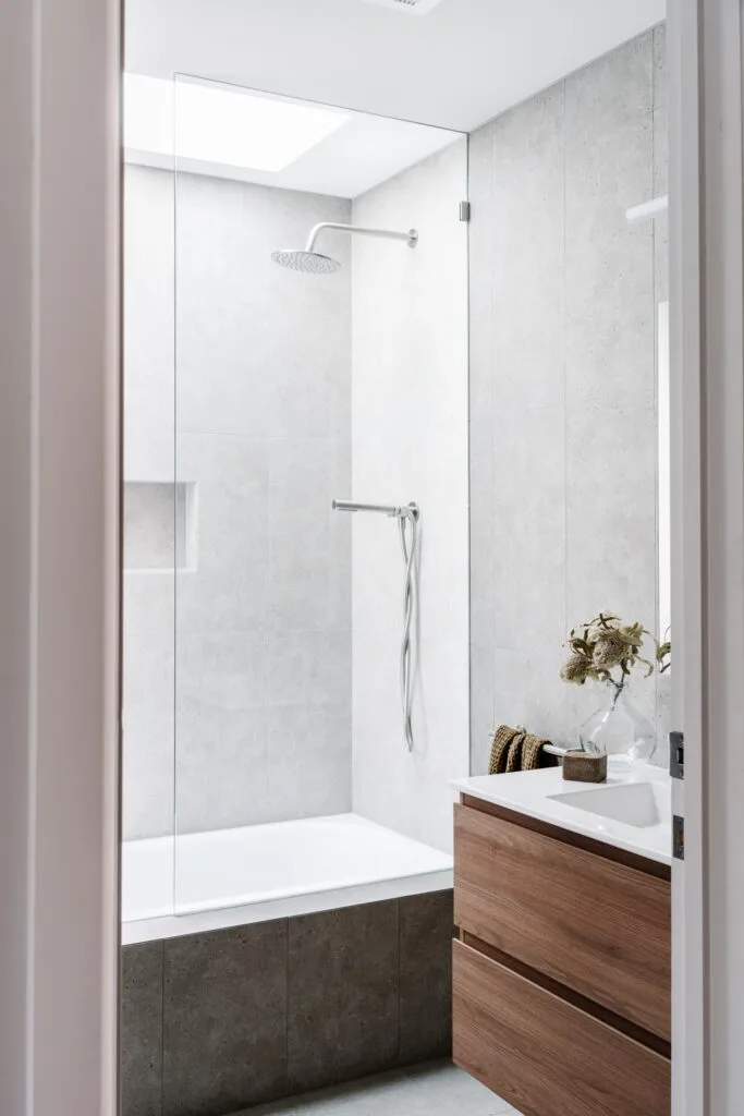 Timber and grey tile family bathroom with skylight.