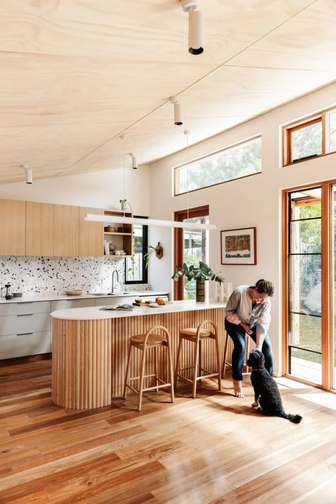 Timber kitchen with owner Claire and a cavoodle.