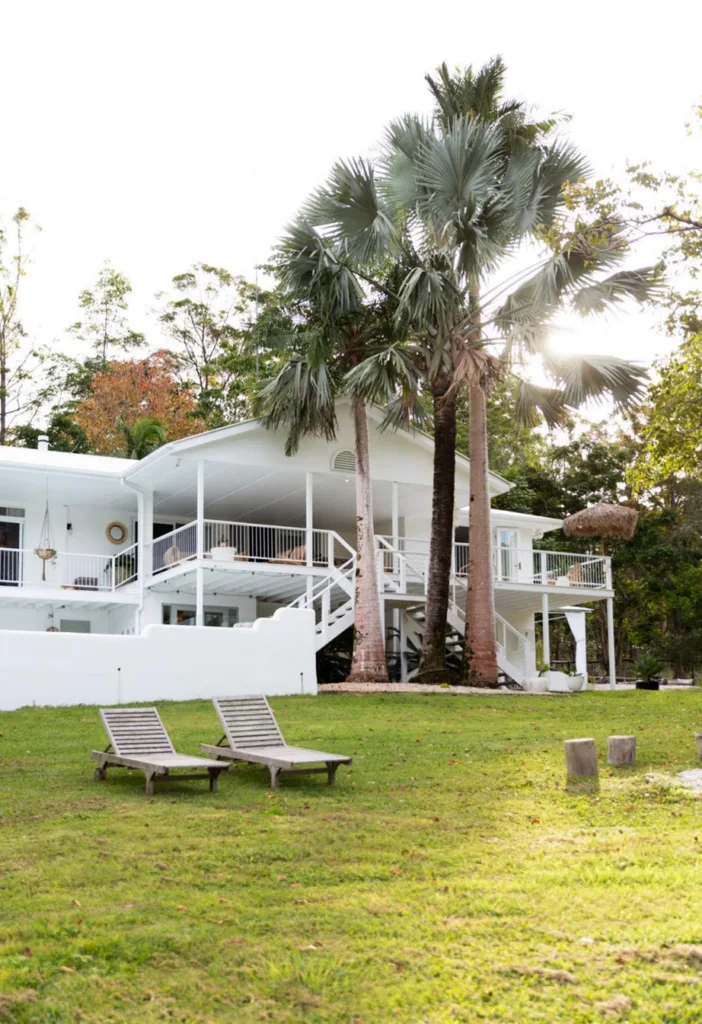 Hamptons coastal chic white-on-white facade and garden lawn.