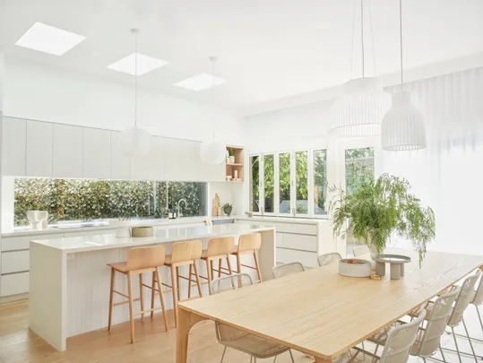 Contemporary renovated Scandi style kitchen with window splashback and skylights.