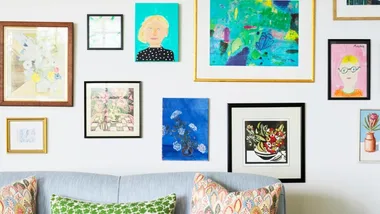 Gallery wall of artworks displayed above a sofa