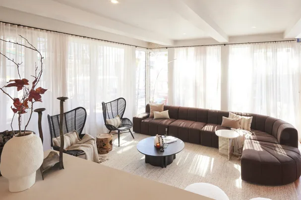 Japandi style living room with large curved sofa and floor to ceiling windows from The Block House 4.