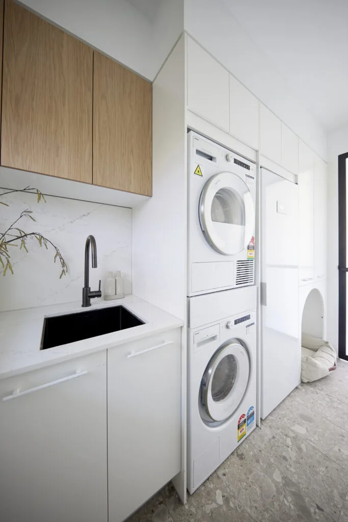 White and marble laundry with timber upper shelving and dog bed cut out.