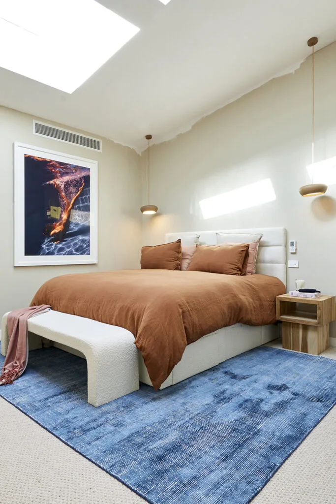 Blue and rust bedroom with photographic print on the wall.