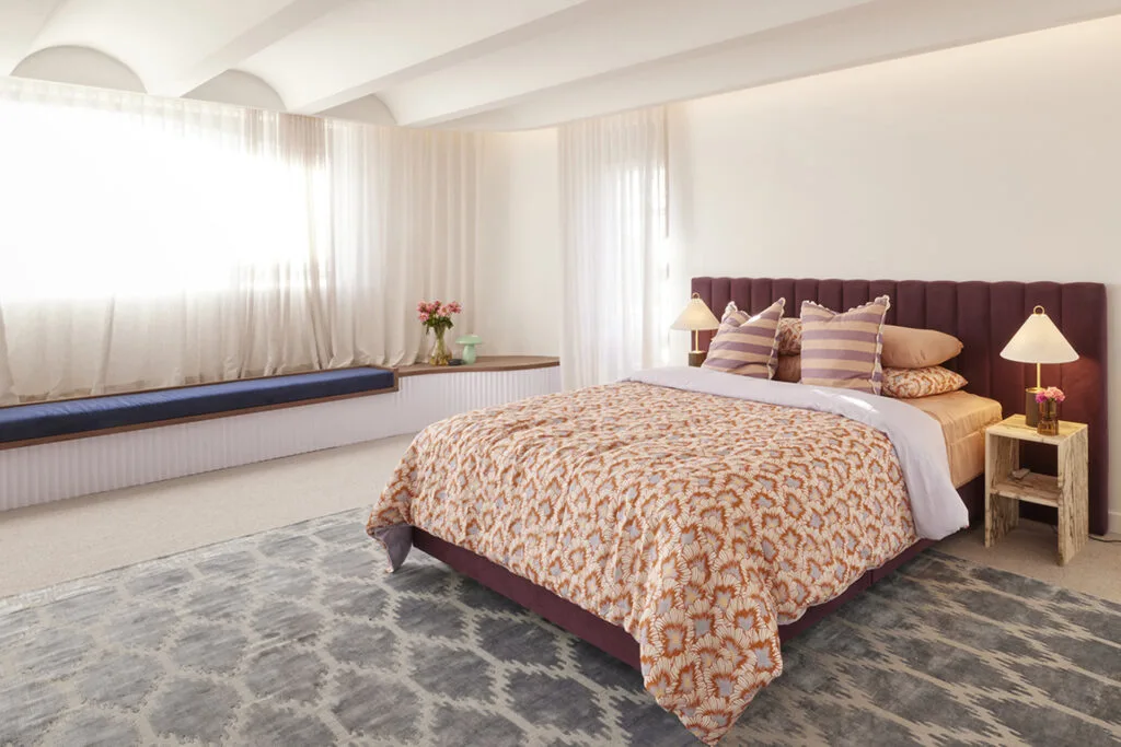 Large master bedroom with fluted ceiling and window seat.