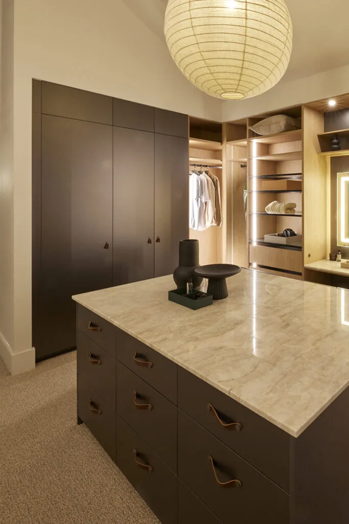 Luxurious walk in wardrobe with marble island bench.