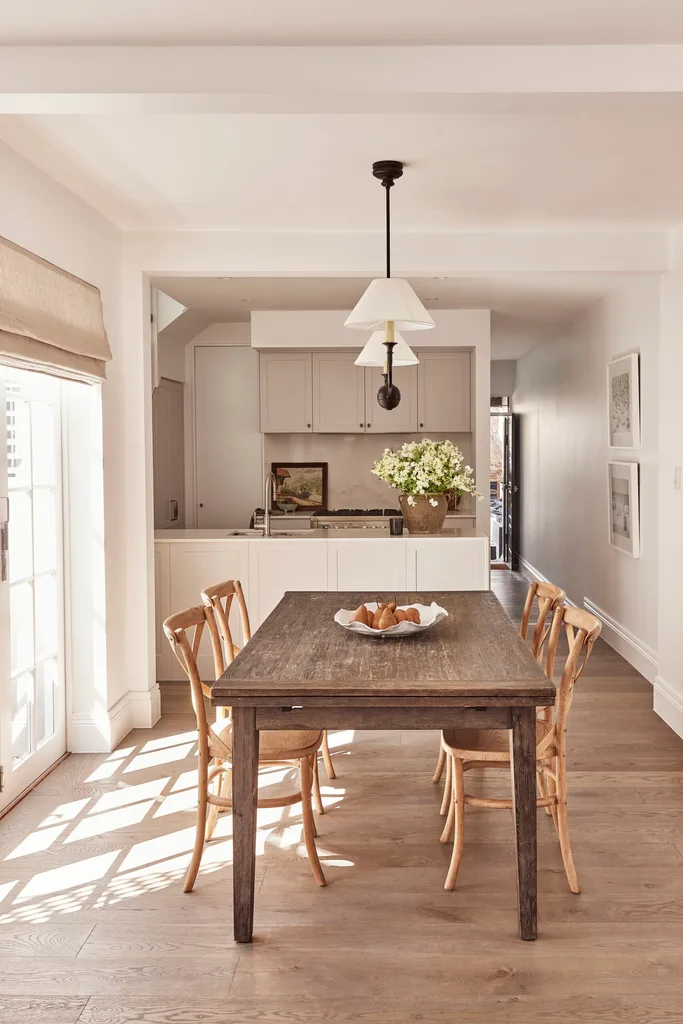 A neutral coloured dining area leading to the kitchen with hybrid floors