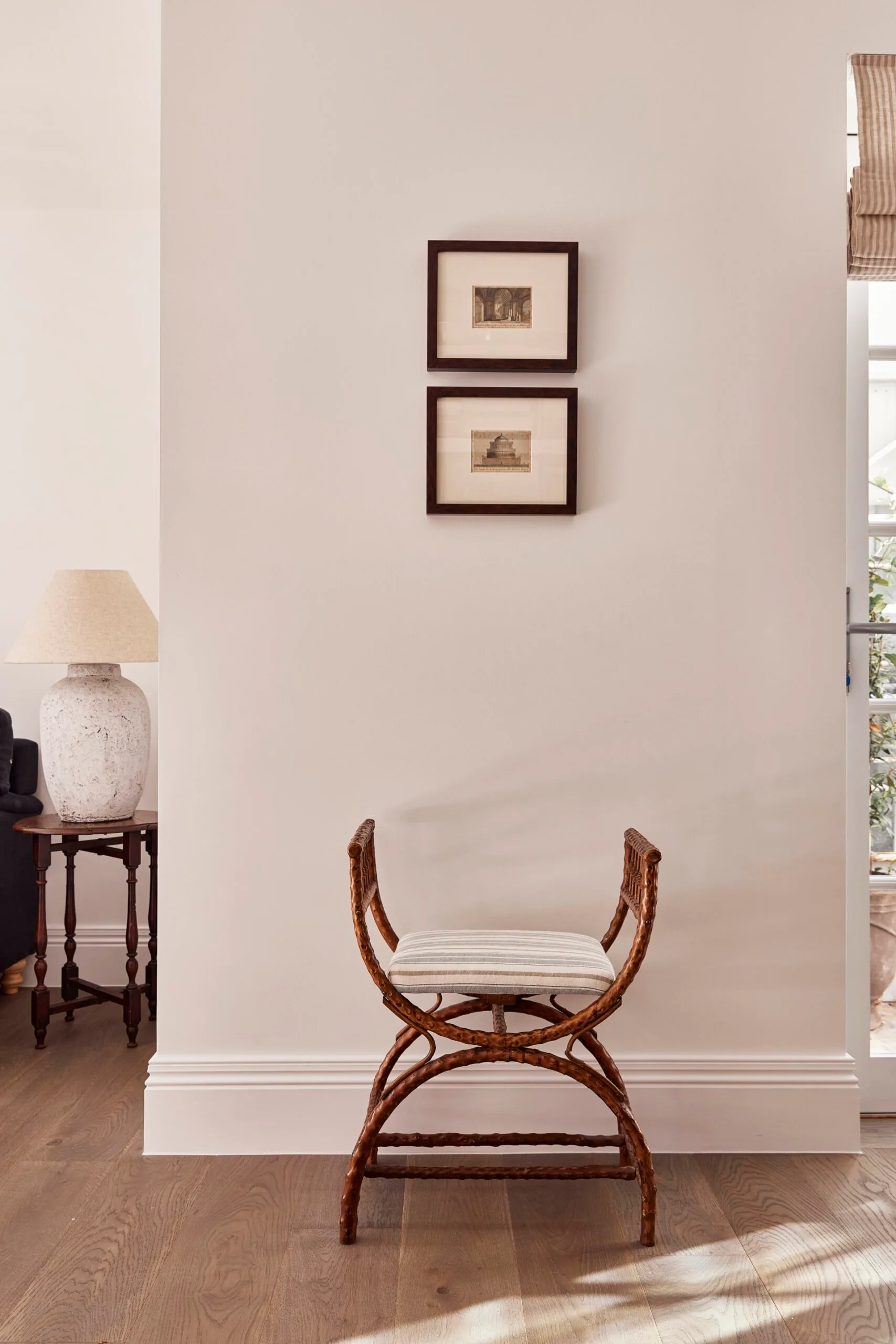 Picture frames hang above a French style chair.