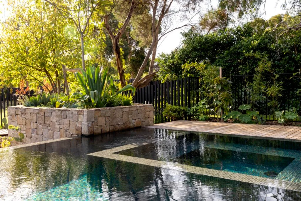 Infinity pool surrounded by gums and a stone planter.