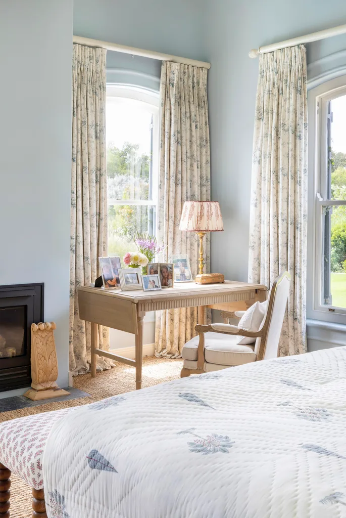 Classic English sky blue main bedroom with study desk and fireplace.