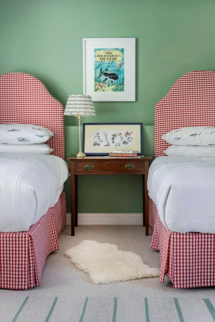 Children's bedroom with green walls and red gingham beds.