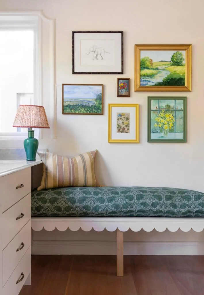 Kitchen bench in blue patterned upholstery below wall art.