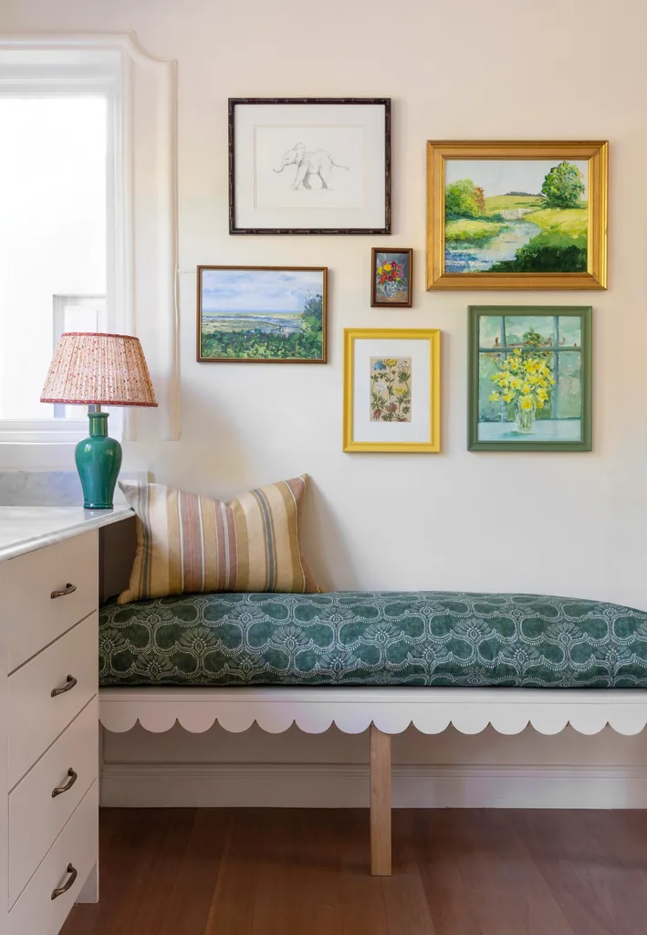 Kitchen bench in blue patterned upholstery below wall art.