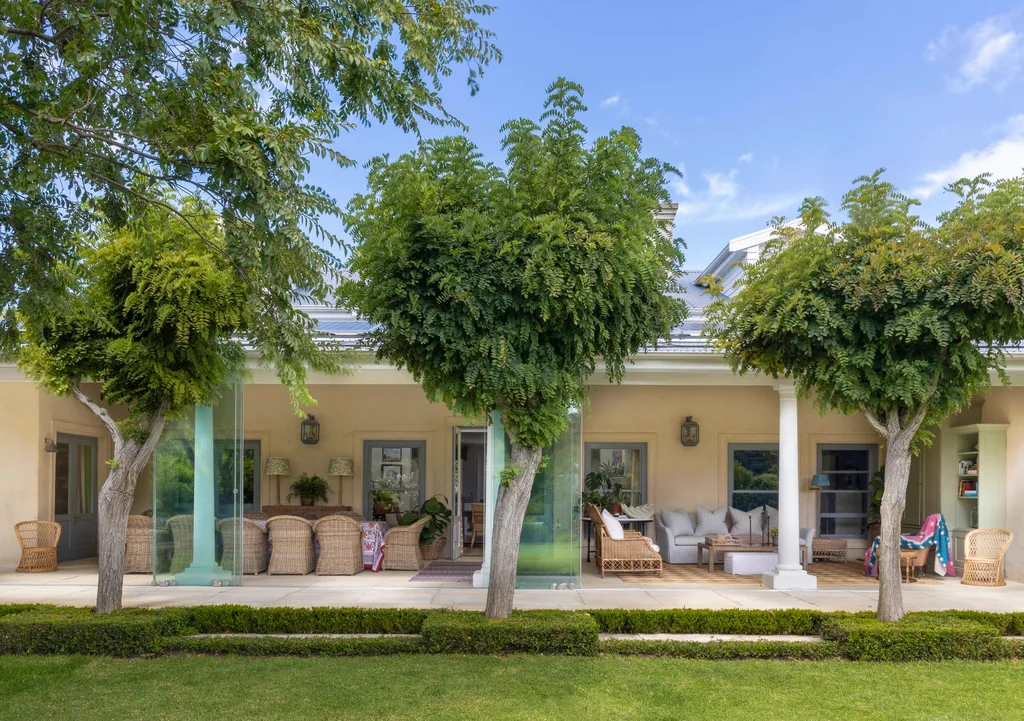 Garden trees and veranda with white columns.