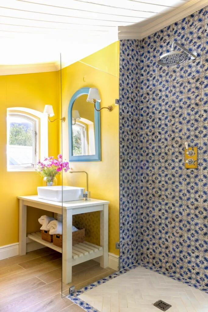 Eclectic yellow and blue-tiled guest bathroom.