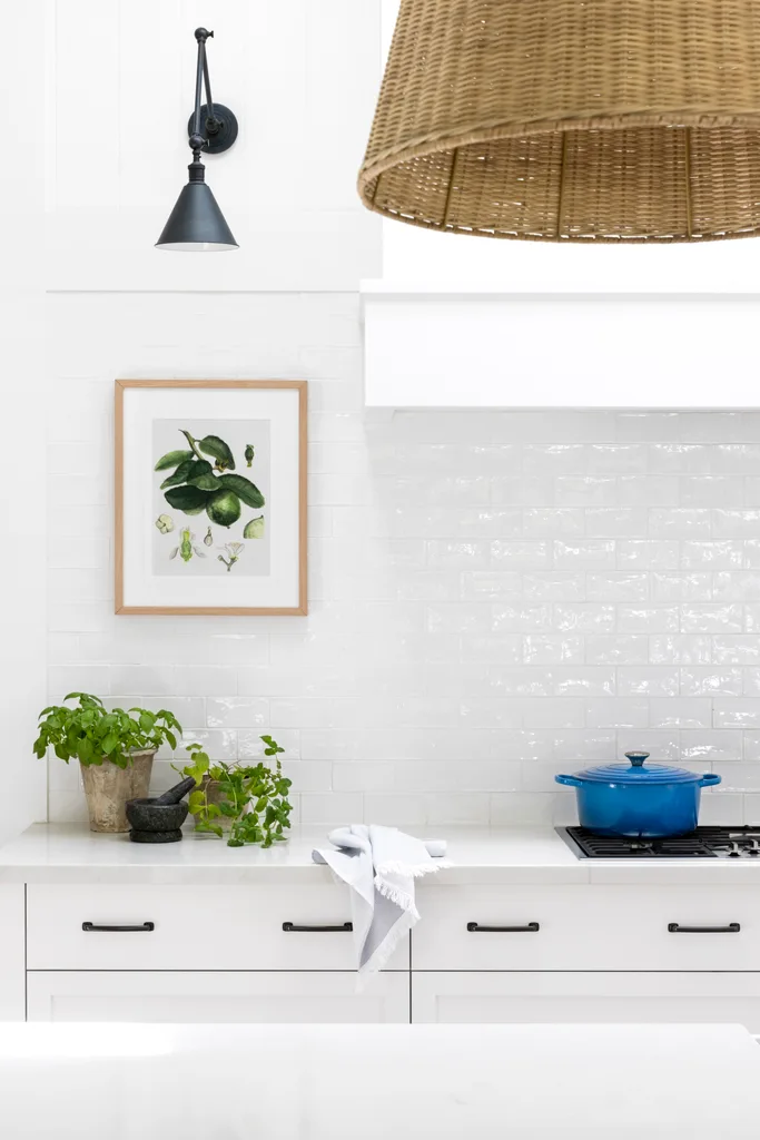 All-white hamptons style kitchen, cooktop and splashback.