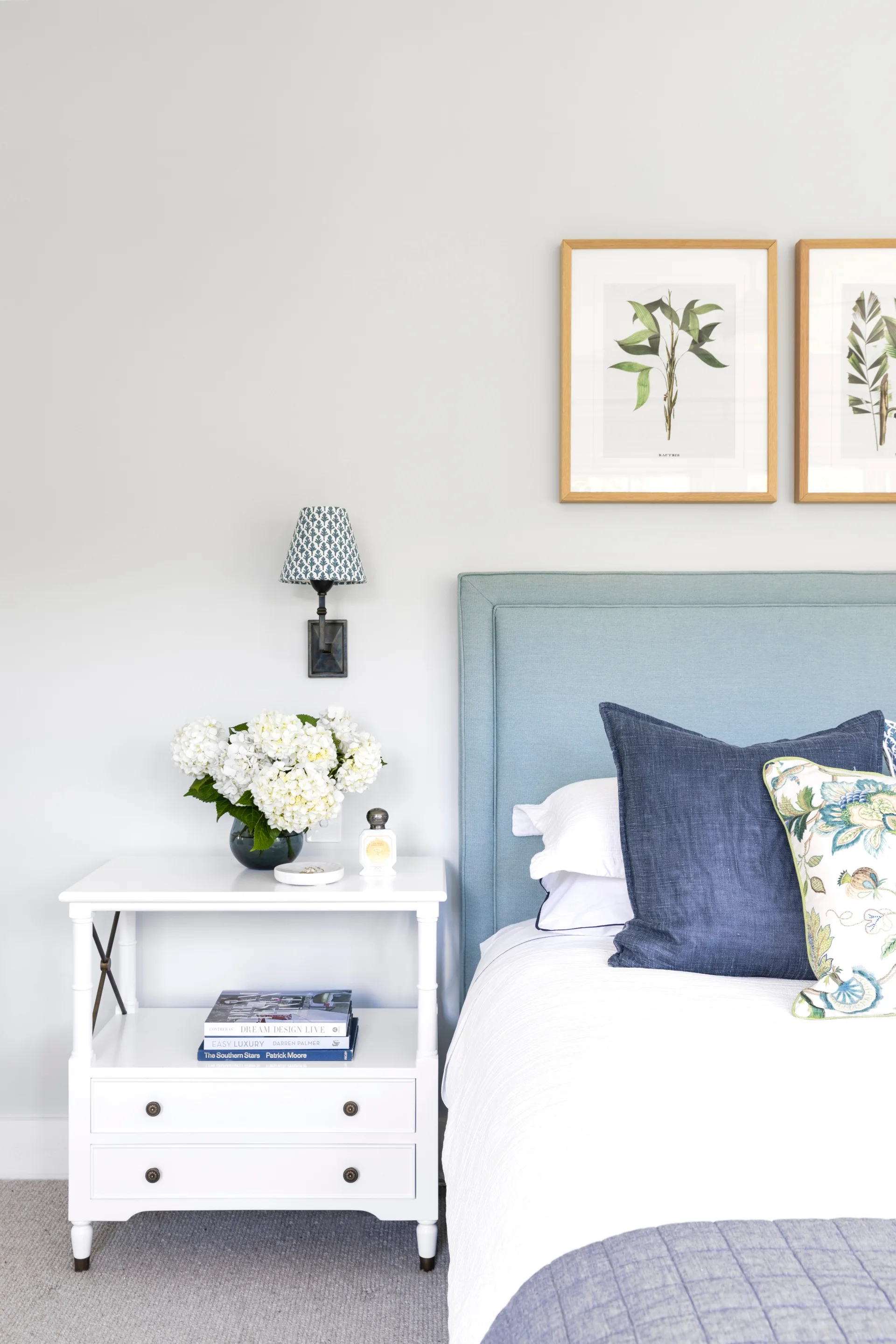 Blue and white contemporary coastal bedroom with side table and soft bedhead.