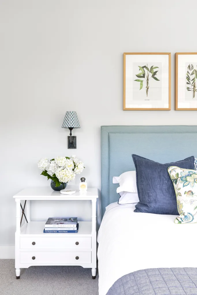 Blue and white contemporary coastal bedroom with side table and soft bedhead.