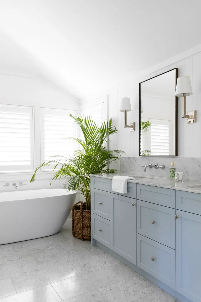 Contemporary coastal ensuite, blue vanity and rounded bath.