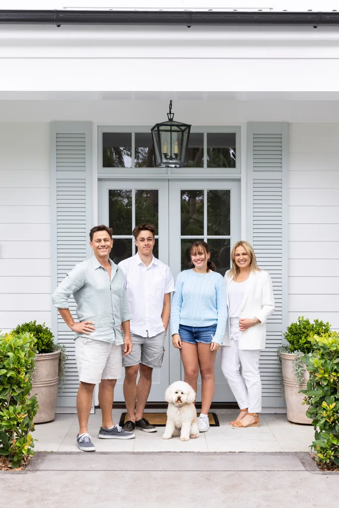 Family shot outside the home's blue French door entrance.