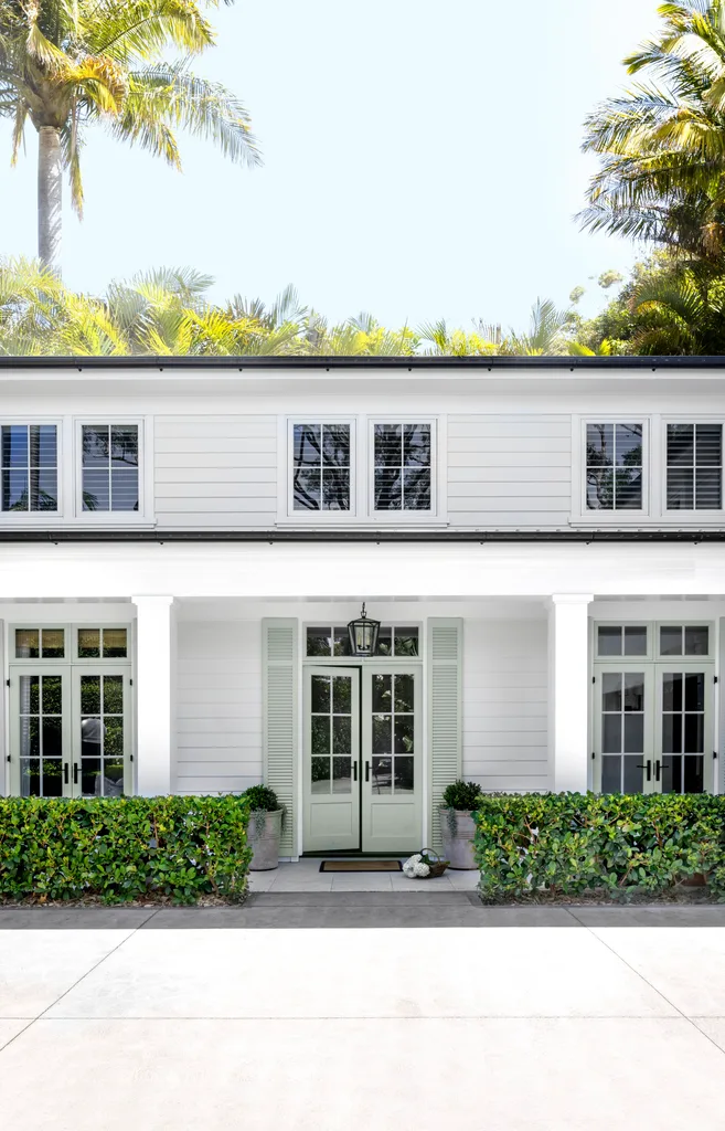 Hamptons home white front facade and garden hedges.