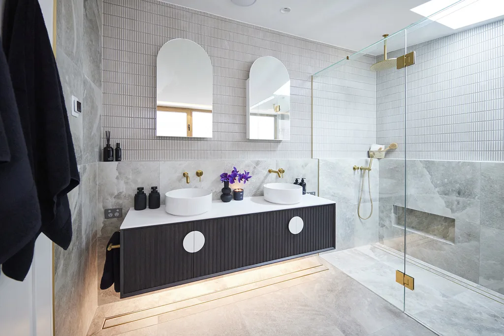 Ensuite bathroom with finger tiles, double vanity and brass hardware.