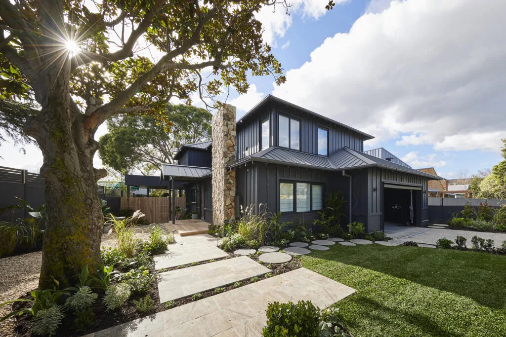 Steph and Gian's front yard on The Block 2023 featuring wide travertine pavers, mature magnolia tree and front lawn.