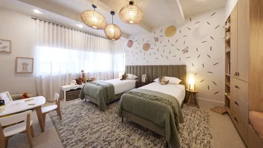 Twin kids' room with two single beds and an olive and neutral colour scheme