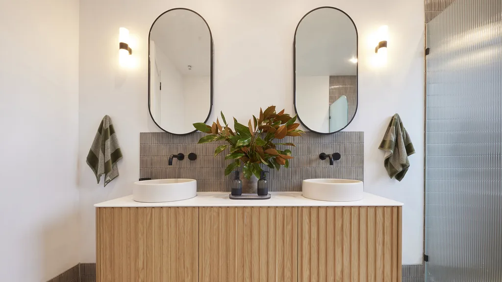 Contemporary bathroom with double timber vanity and finger splashback tiles.