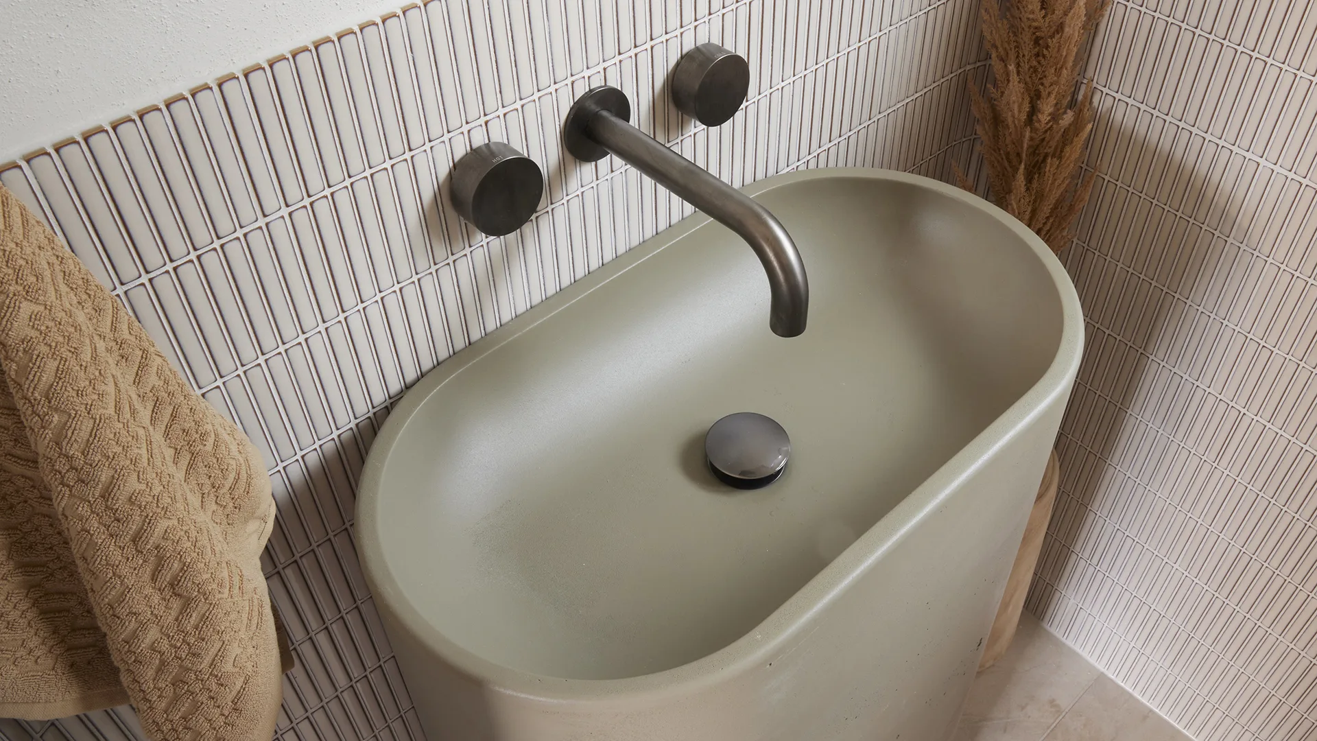 Neutral, contemporayr powder room with statement stone vanity and finger mosaic tiles.