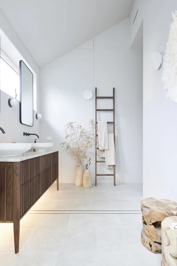 Japandi ensuite bathroom with dark timber vanity and floating mirrors.