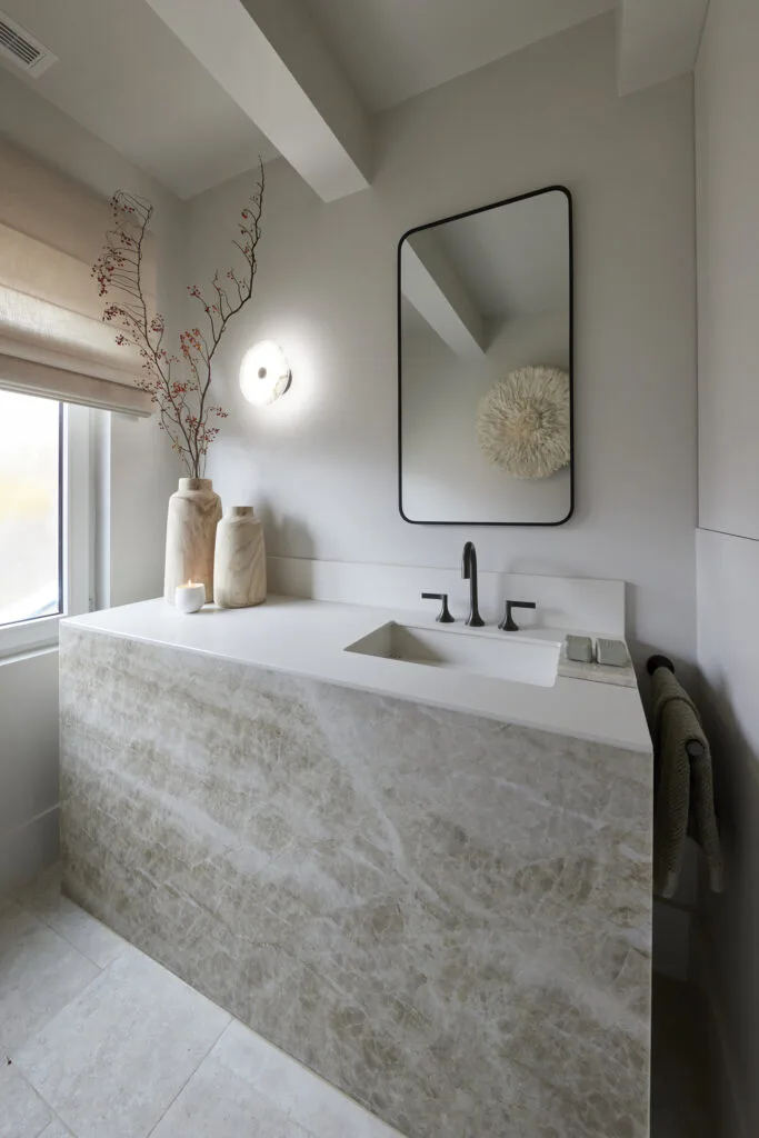 Contemporary powder room with custom stone vanity and neutral colour scheme.