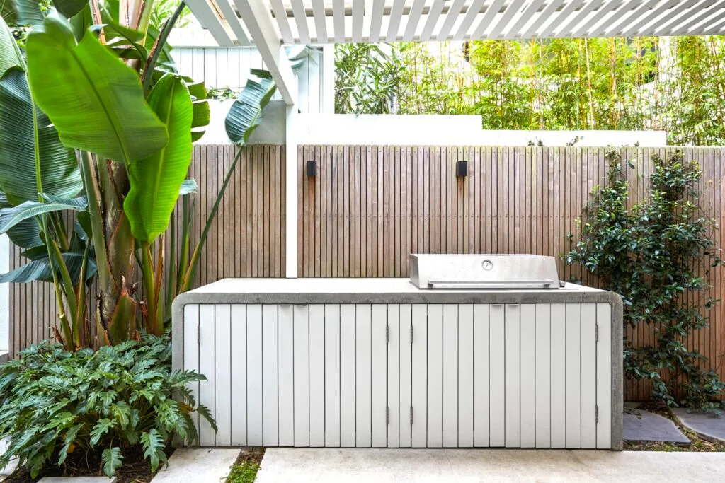 Outdoor kitchen barbeque and tropical plants.