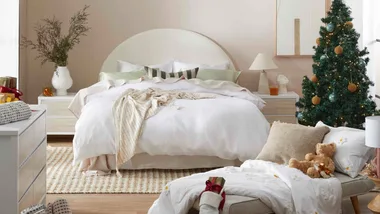 A white bed with a Christmas tree, which you can get during the Temple & Webster Black Friday sale.