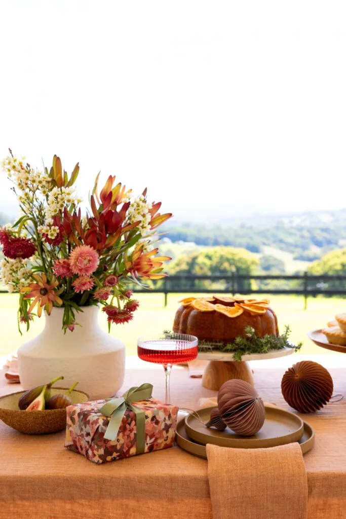 A Christmas table laid with presents, food and native flowers.