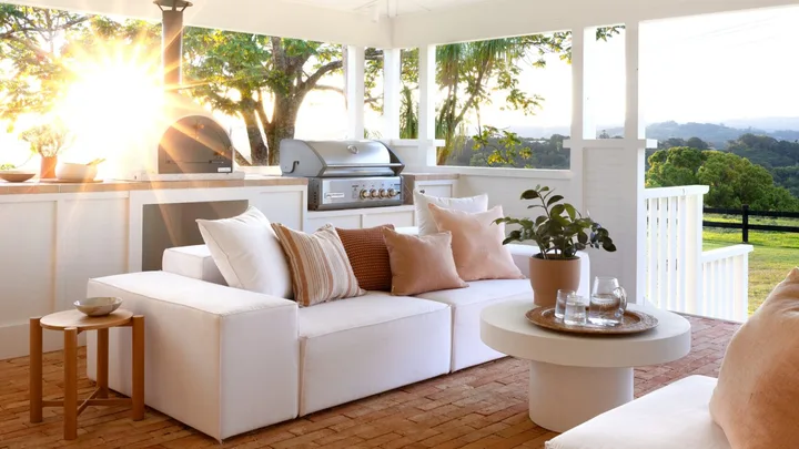 The outdoor living area with a white raised ceiling and sofas.