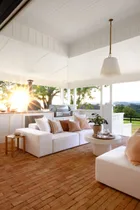 The outdoor living area with a white raised ceiling and sofas.